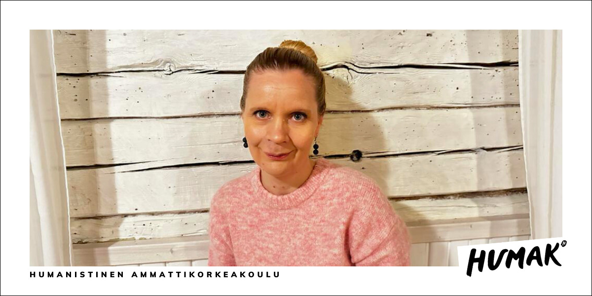Katri Haapakorva valkoisen lautaseinän edessä